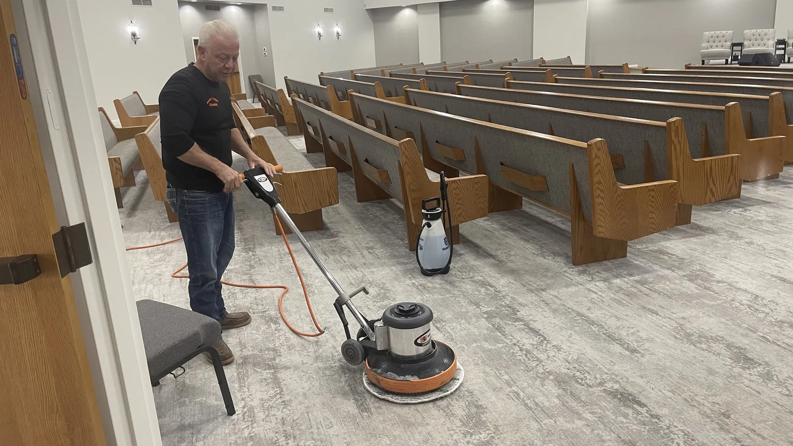 Gordon Brake using carpet-cleaning equipment in a church sanctuary